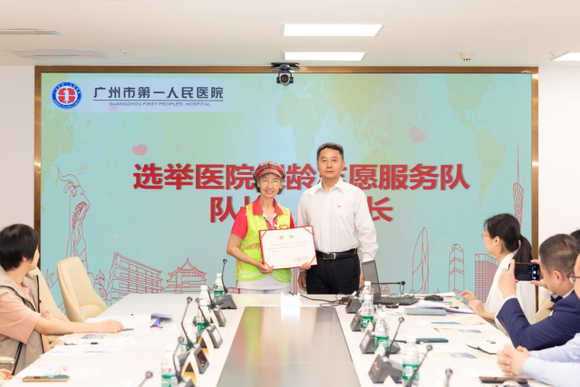 广州市第一人民医院党委副书记、南沙医院党总支书记李铠向仁心银龄志愿服务队队长颁发聘任证书